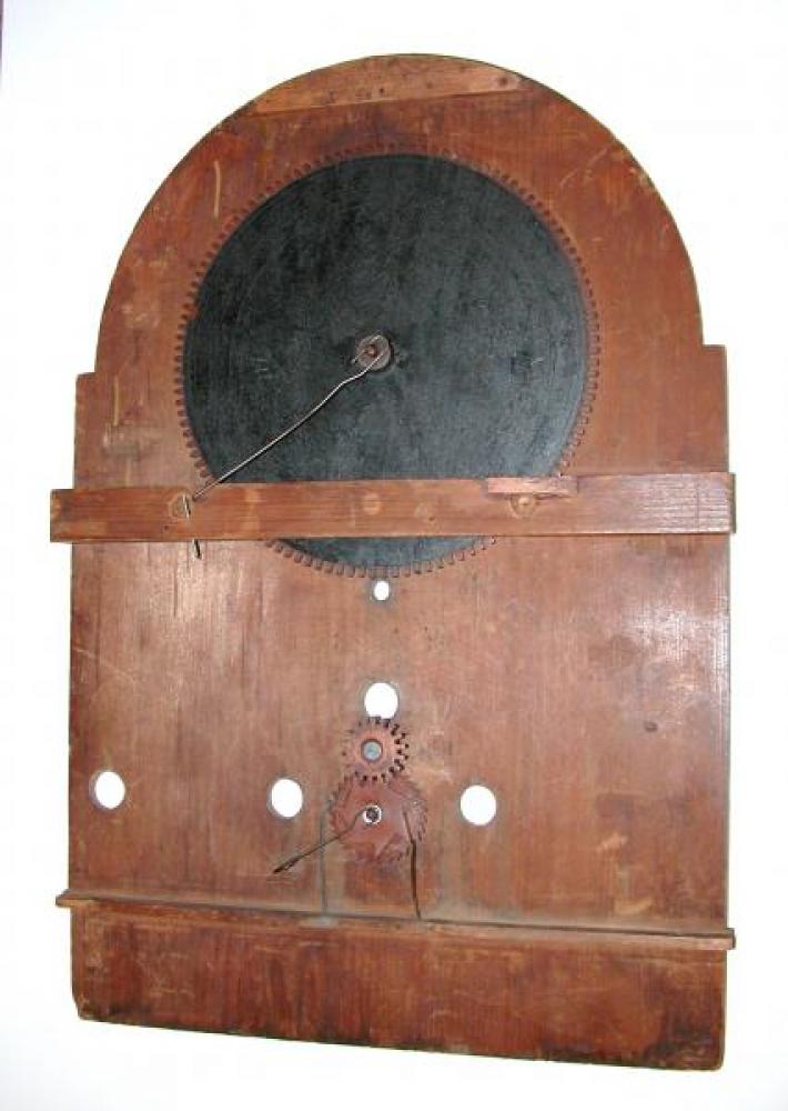 The back of the wood dial; the dark, large round "gear" is the back of moon phase dial.