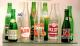 Some mid 20th century glass soft drink bottles that relate to advertising clocks for these products.